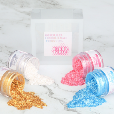 4 edible glitter colors displayed with marble background