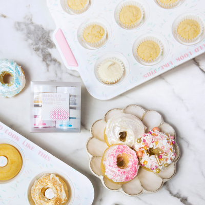 donut pan, mini muffin pan, edible glitter, and donuts displayed on countertop